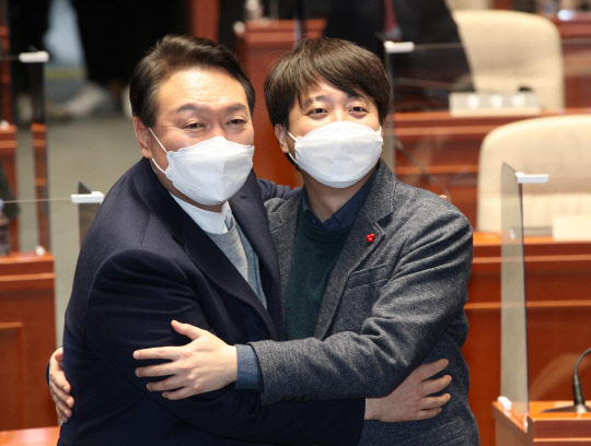 극한 대치 끝에 전격 화해한 윤석열 국민의힘 대선 후보와 이준석 대표가 지난 6일 저녁 국회에서 열린 의원총회에서 손을 맞잡고 있다. 국회사진기자단